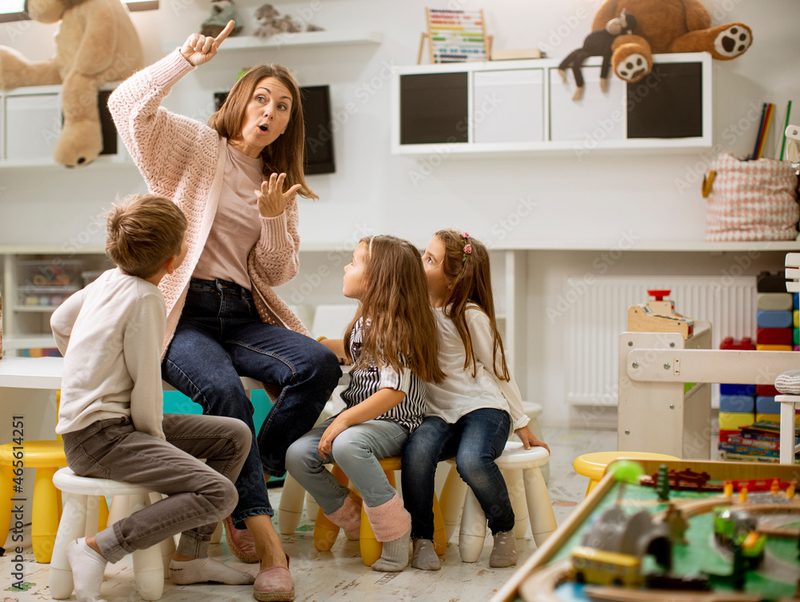 Erzieherin spielt mit Kindern in der Kita